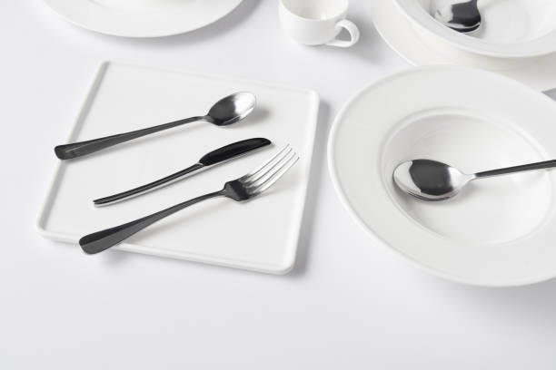 istock close up view of various plates, cup, fork, knife and spoons on white table 1002740712