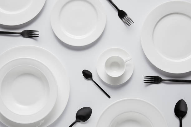 istock top view of various plates, cup, black spoons and forks on white table 1002741018