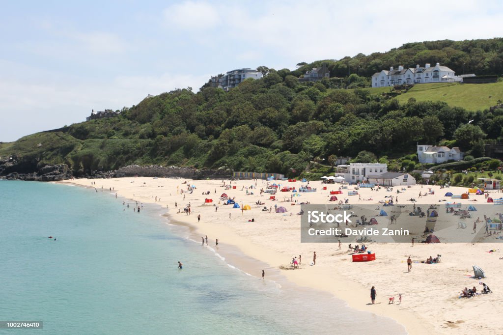 Holidaymakers and sunbathers on Newquay beach with azure seas. Newquay, Cornwall, UK Beach Stock Photo