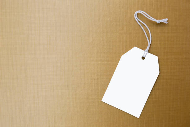 istock White paper price tag on shiny gold texture background 1002757086