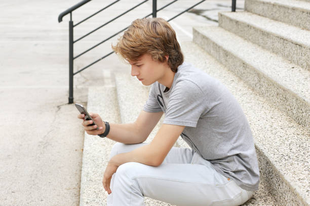 istock Using smart phone.Teenage boy typing text message. 1002757394