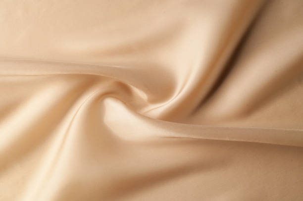 istock Texture background of fabric. Beige fabric. Silk fabric wallpaper texture background pattern in sepia pastel yellow cream beige tint: Lovely natural silk textured textile 1002764890
