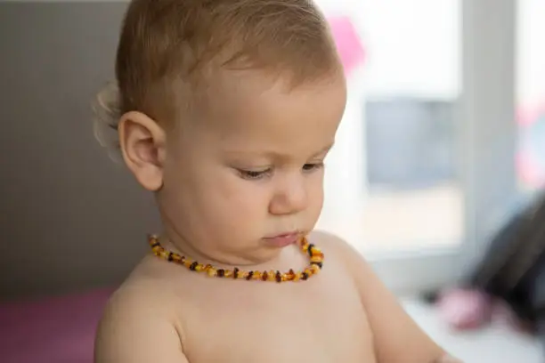 baby toddler wearing amber teeth pain relief neckless