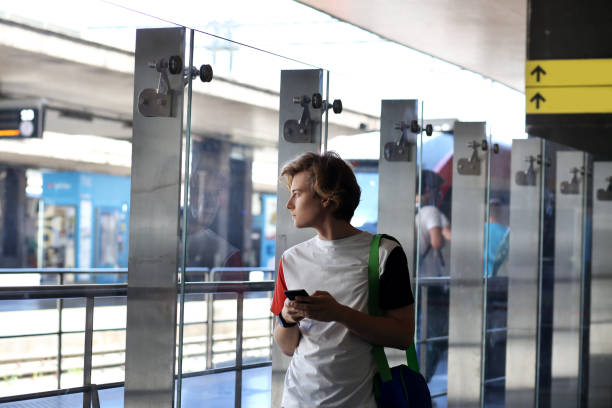 istock Teenage boy using smart phone,railway station 1002768916