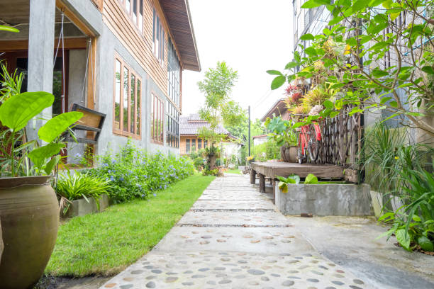 Landscape garden. Stone pathway in tropical garden. Stone walking way made from cement and pebble with green lawn in countryside. Outdoor garden exterior design.