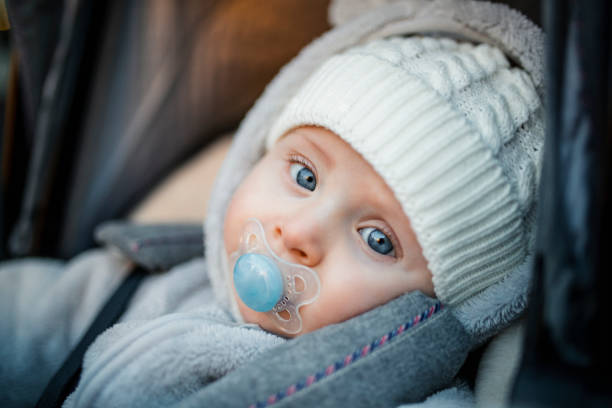 Cute Baby Boy Little baby boy sitting in his stroller wearing warm clothing. baby stroller winter stock pictures, royalty-free photos & images