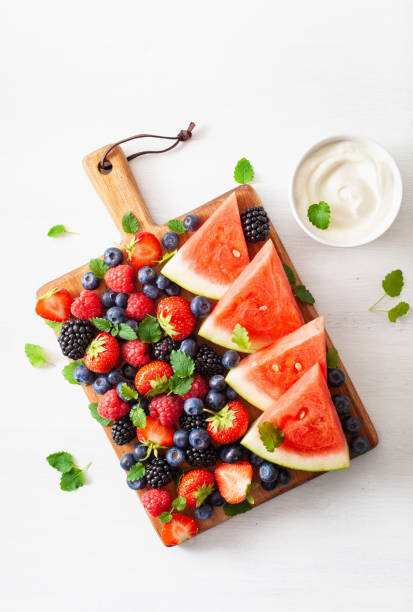 istock fruit and berry with yogurt over white. blueberry, strawberry, raspberry, blackberry, watermelon 1002779236