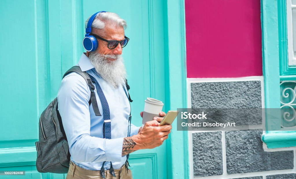 Trendiga senior mannen med musik smartphone app och dricka kaffe i downtown center Utomhus - mogen mode man ha kul med nya trender teknik - Tech och glada äldre livsstilskoncept - Royaltyfri Pensionär Bildbanksbilder