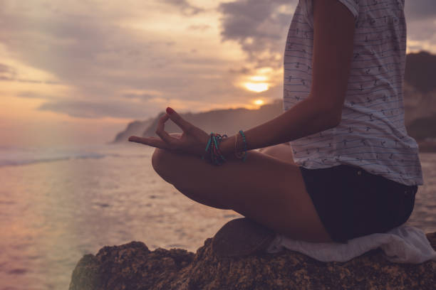 istock Young woman practicing yoga on the beach. 1002783508
