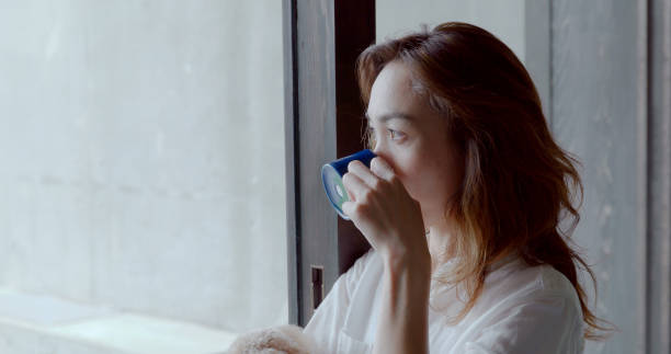 istock Young female drinking coffee at home. 1002786952