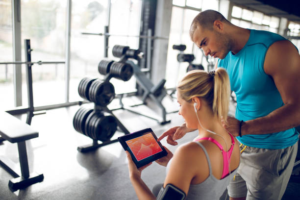 istock Trainer explaining workout regime to young sporty woman 1002792578