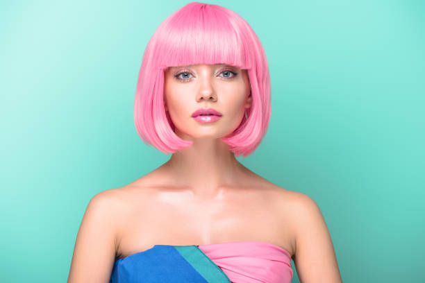 young woman with pink bob cut looking at camera isolated on turquoise