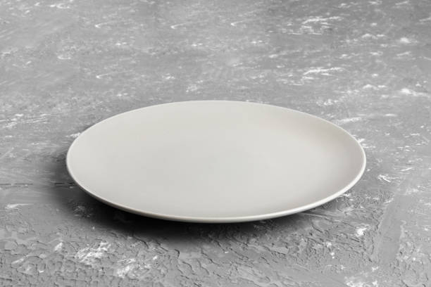 istock Perspective view. Empty white plate on wooden background 1002793736