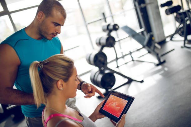 istock Trainer explaining workout regime to young sporty woman 1002800894