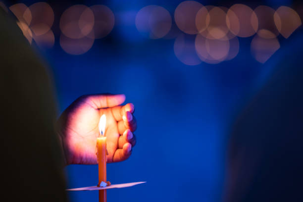 istock Candle burnin and hald holding in night on bokeh background 1002801738