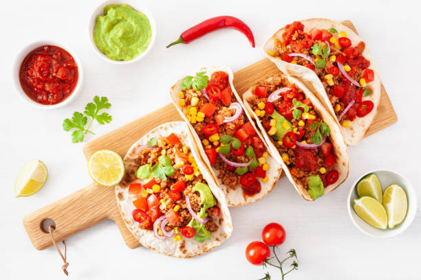 istock mexican beef and pork tacos with salsa, guacamole and vegetables 1002801944