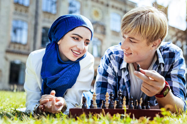 屋外チェスのゲームを楽しんでいる若い人たちを輝かせてください。 - chess mate ストックフォトと画像