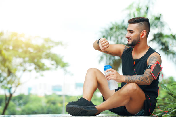 istock Athletic man checking smartwatch outdoors 1002828380