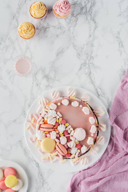 istock flat lay with pink birthday cake with marshmallows, cupcakes and milkshake on marble table 1002830402