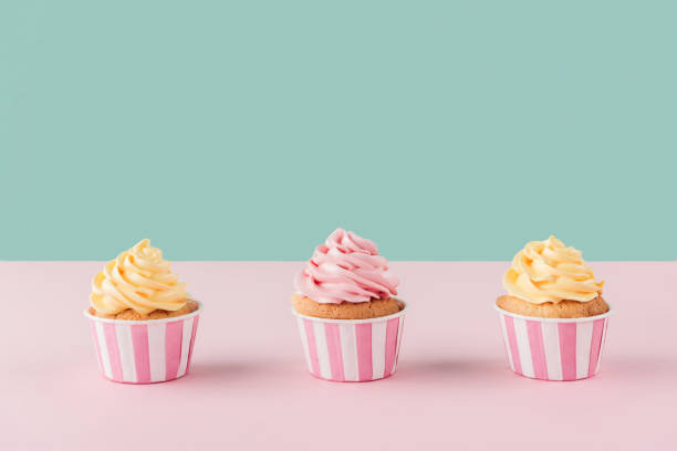 istock three cupcakes with buttercream in row on pastel background 1002838248