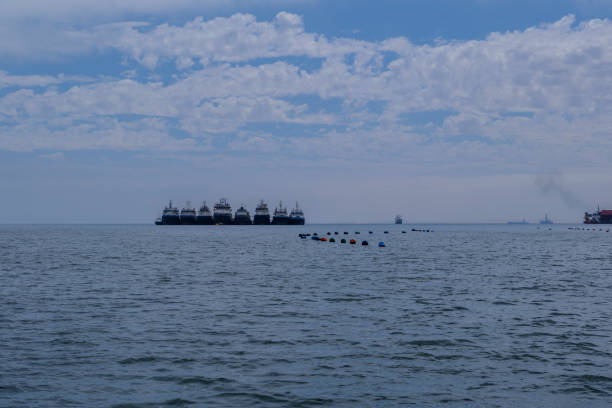 istock Oyster farm buoys and cargo ships 1002847718