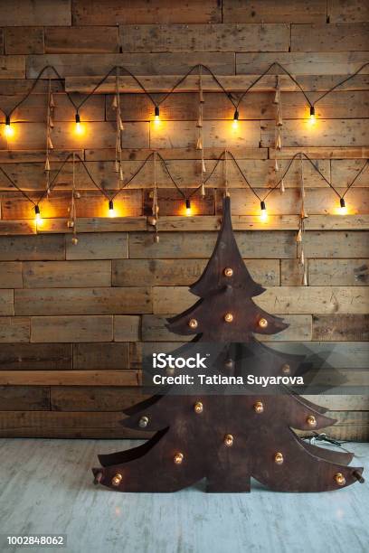 Alternative Wooden Christmas Tree A Handmade New Year Tree With Light Bulb On The Floor On Wooden Background Loft Interior Copy Space Stock Photo - Download Image Now