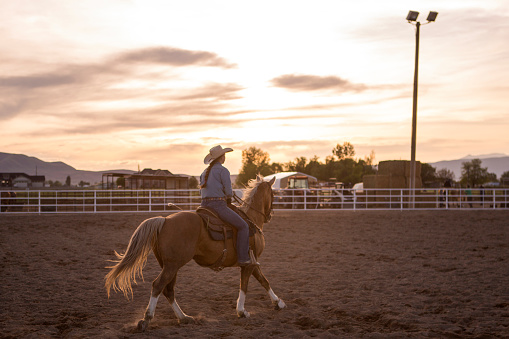 cowgirl Cowboy riding horse  at rodeo paddock arena in spanish fork of Salt lake City SLC Utah USA