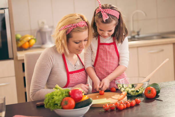 istock Little girl cutting cherry tomato 1002852744