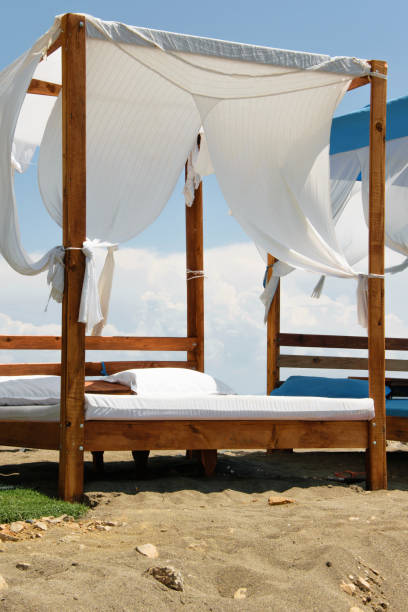 istock Luxury and romantic bed on the seashore for relaxing time (holidays/vacations), white fluffy clouds in the background 1002852788