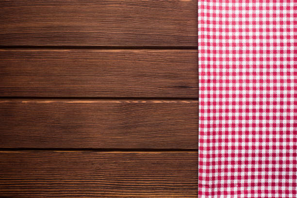 istock Napkin in a red and white cage on a wooden background, texture, 1002860244