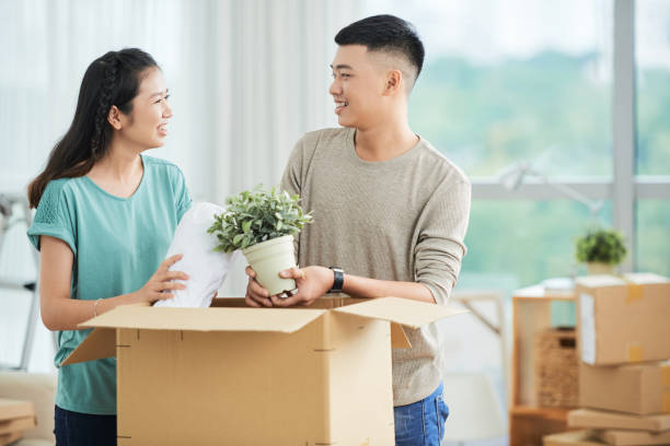 istock Happy Asian couple packing things in carton 1002860248