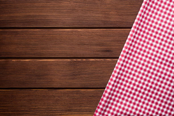 istock Napkin in a red and white cage on a wooden background, texture, 1002860412