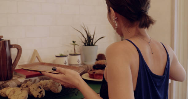 istock Young female clerk display muffins. 1002861788
