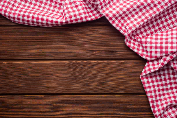 istock Napkin in a red and white cage on a wooden background, texture, 1002862828