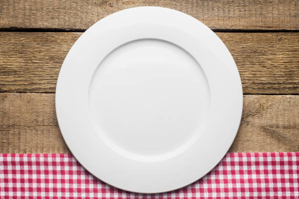 istock empty plate on a wooden background, a napkin in a red and white 1002863592
