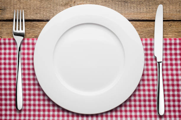 istock empty plate on a wooden background, a napkin in a red and white 1002863804