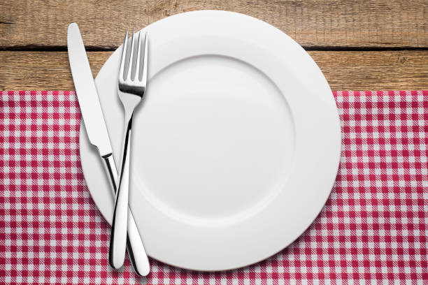 istock empty plate on a wooden background, a napkin in a red and white 1002863888
