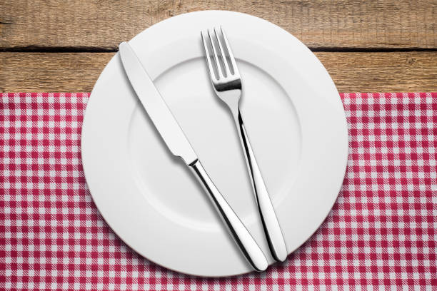 istock empty plate on a wooden background, a napkin in a red and white 1002863962