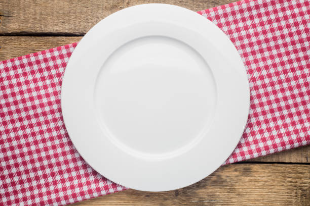 istock empty plate on a wooden background, a napkin in a red and white 1002864030