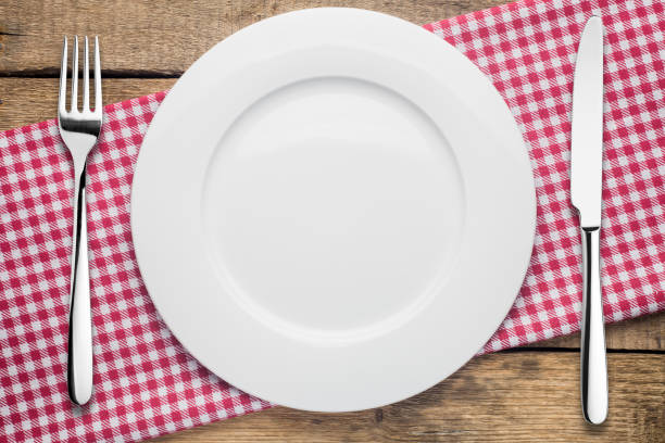 plato vacío sobre un fondo de madera, una servilleta en un rojo y blanco - empty fork fotografías e imágenes de stock