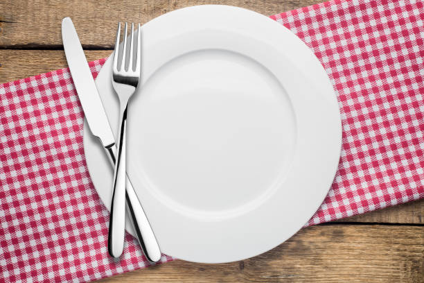 istock empty plate on a wooden background, a napkin in a red and white 1002864392