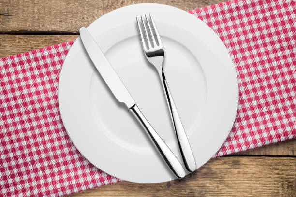 istock empty plate on a wooden background, a napkin in a red and white 1002864482