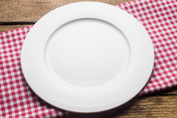 istock empty plate on a wooden background, a napkin in a red and white 1002864556