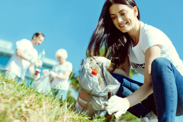 istock Attractive brunette collecting rubbish from park 1002867736