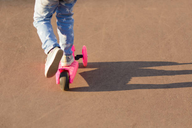 istock Little girl riding a scooter 1002868928