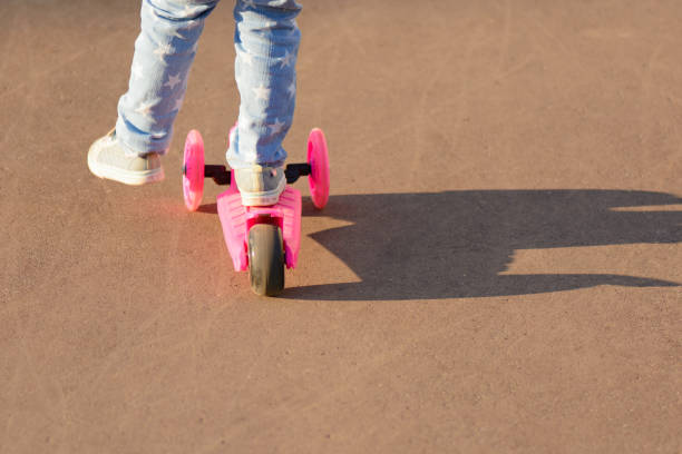 istock Little girl riding a scooter 1002868938
