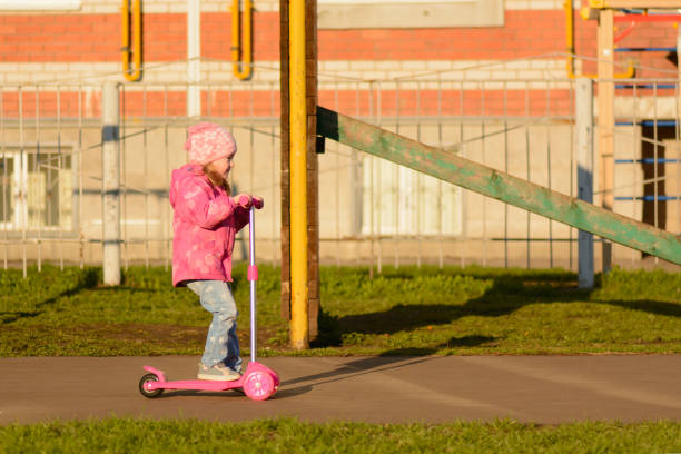 istock Little girl riding a scooter 1002868986
