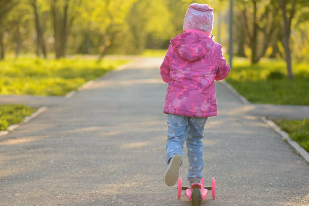istock Little girl riding a scooter 1002869038