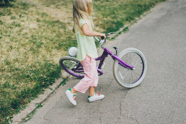 istock side view of kid with bicycle on street 1002871644