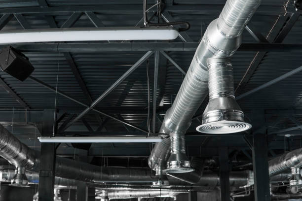 istock Ventilation system on the ceiling of large buildings. Ventilation pipes in silver insulation material hanging from the ceiling inside new building. 1002871972